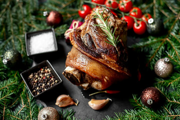 Christmas pork knuckle baked in the oven against the background of a Christmas tree and Christmas decorations