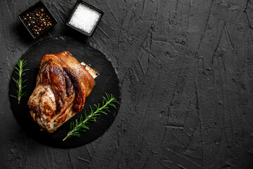 pork knuckle baked in the oven on a stone background  with copy space for your text - obrazy, fototapety, plakaty