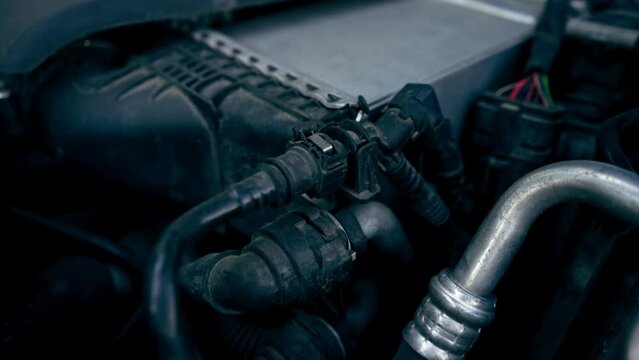 close-up of details under the hood of a car engine battery electricity wires oil compartment car repair