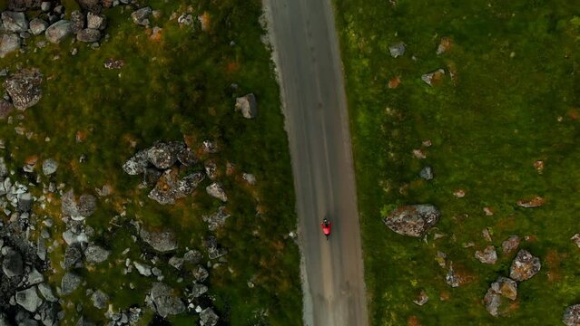 Top down aerial view on cyclist ride on dirt road in the nature. Drone shot of mountain or gravel cyclist on a road.