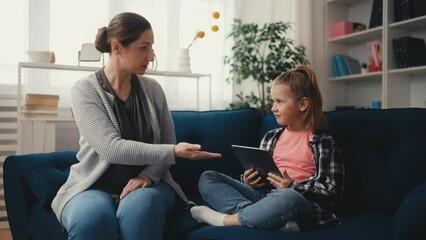 Mom trying to take the tablet away from naughty child, problems of upbringing