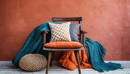 a collection of vibrant pillows and a cozy blanket are placed on a wooden chair against a textured terracotta wall