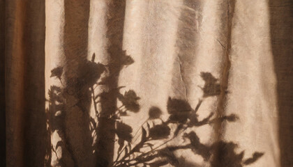 natural warm neutral beige textile background with floral shadows abstract plant silhouette in sunset light on linen texture curtain