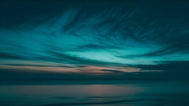 The Teal Ombre Sky at Dusk paints a mesmerizing picture of the evening horizon. This photograph captures a gradual transition of colors, beginning with a deep teal at the bottom and gracefully fading 