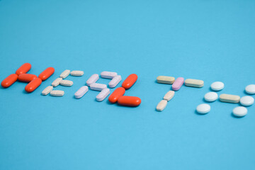 health word from Colorful Medicine Pills isolated on blue background, supplement, vitamin, colorful