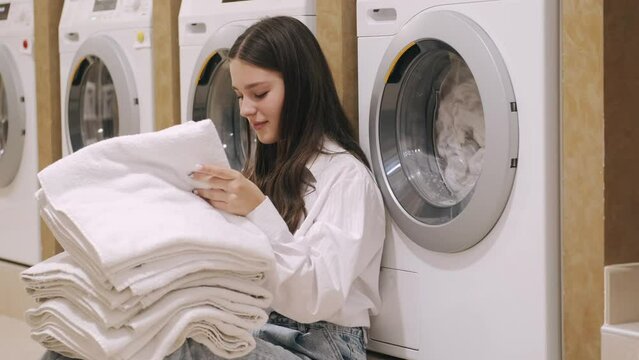  two sisters  cleaning cloath using the washer and arranging them and putting it back in the closest