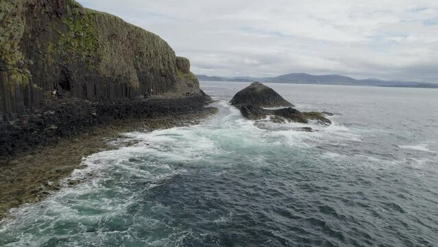 Aerial view flying over aFingal's Cave on Staffa Island, west of Isle of Mull in Scotland. Calm waves touching the rocks.