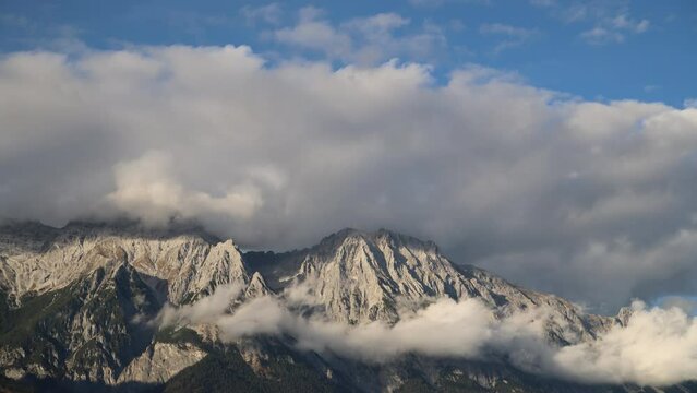 Cloudiness over the peaks of the Tyrolean Alps on a clear day.
