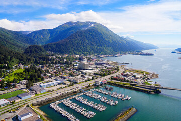 Aerial view of the downtown Juneau, the state capital of Alaska, USA, along the Gastineau Channel in the Arctic - Harris Harbor towered by Alaskan summits next to Douglas Bridge - obrazy, fototapety, plakaty