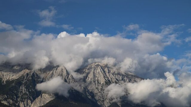 Cloudiness over the peaks of the Austrian Alps on a clear day.