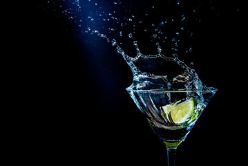 splash in a glass with lime slice on a black background