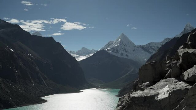 beautiful turquoise water of the lake at laguna paron lagoon in the high andes mountains of the cordillera blanca at huascaran, Peru, with snow covered mountain peaks on a bright sunny day.