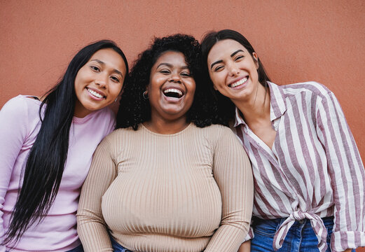Young latin women smiling in front of camera - Multiracial girls having fun together in the city