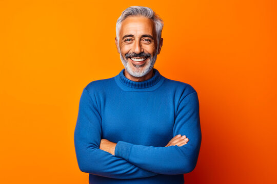 Homme s&eacute;nior avec barbe et souriant, les bras crois&eacute;s
