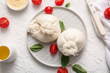 Plate with tasty Burrata cheese on white background