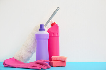 Cleaning supplies on blue table against white background