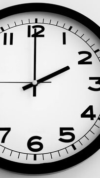 Closeup of White Clock Face on white wall clock, arrows show 14.00 or 02.00