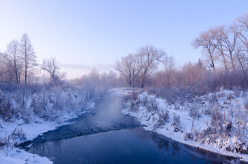 Winter landscape, frosty early morning on the river. Snow on the trees and frost.