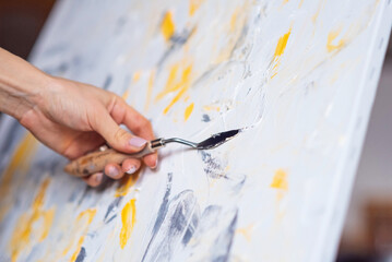 The artist paints an abstract painting using mastichin.
