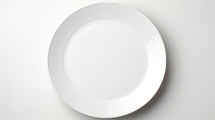 Empty white plate on white background. Top view. Copy space.