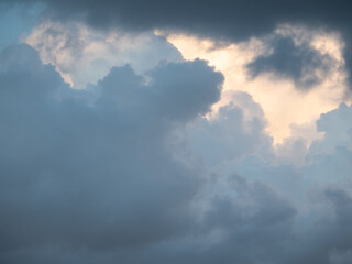 Blue sky after rain,. Beautiful Cumulus clouds flying across the sky, sunset rays, pink and orange shades in the clouds, deep blue sky