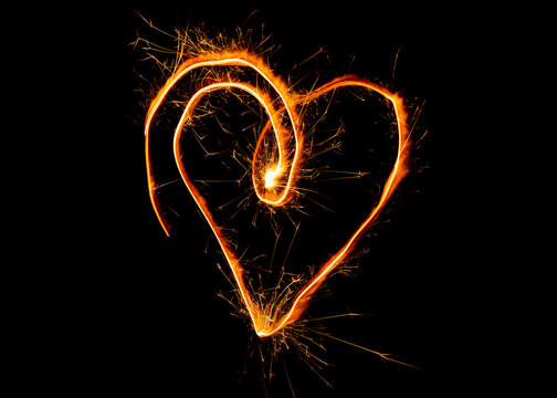 Drawing of a heart with sparklers on a black background