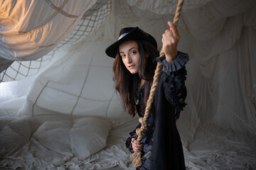 Pirate lady pulls a tightrope, beautiful young brunette in a pirate costume