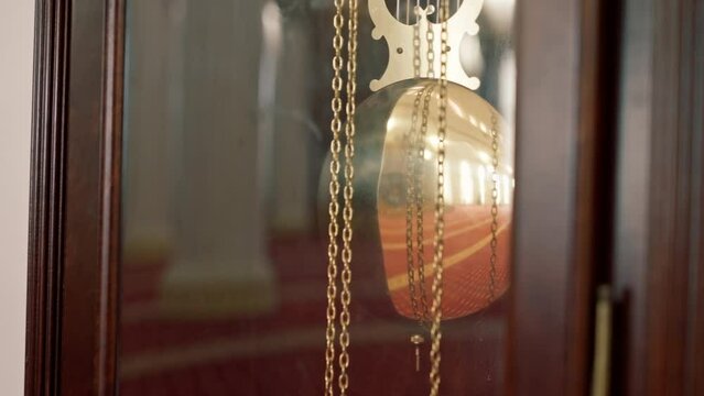 Vintage antique wooden wall clock with barometer hanging on  white wall in a Muslim mosque