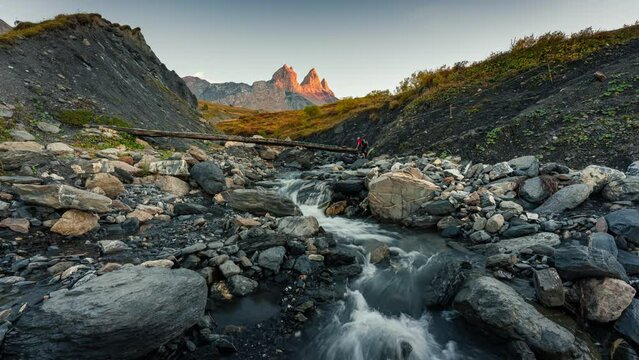 Landscape of iconic three peak mountain and waterfall flowing in the valley of Aiguilles d Arves in French alps on autumn at Savoie, France