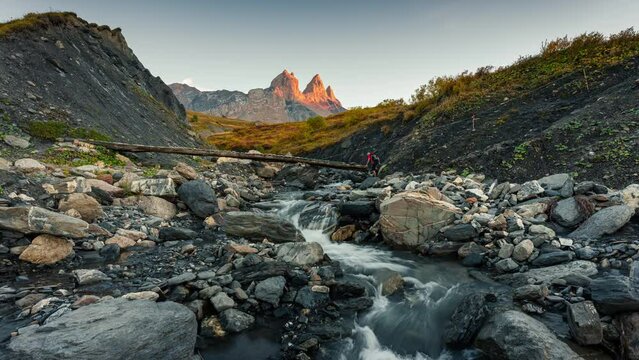 Landscape of iconic three peak mountain and waterfall flowing in the valley of Aiguilles d Arves in French alps on autumn at Savoie, France