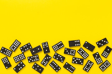 Black domino tiles on color background, top view