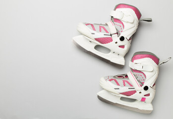 Ice skates on color background, top view