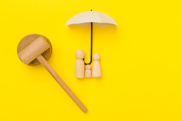 Wooden family figures with judge's gavel on color background,top view