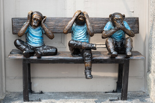 Three monkeys on a bench. Proverbial principle "see no evil, hear no evil, speak no evil"