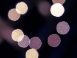 Blurred out-of-focus bright lights of a garland on a dark background close-up