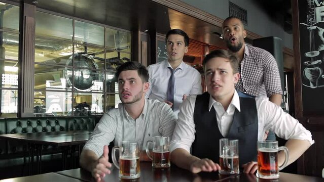 Four friends businessmen drink beer and rejoice