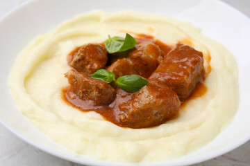 Delicious goulash with mashed potato on table, closeup