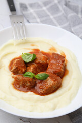 Delicious goulash served with mashed potato on table, closeup