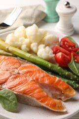 Healthy meal. Grilled salmon steak and vegetables served on white table, closeup