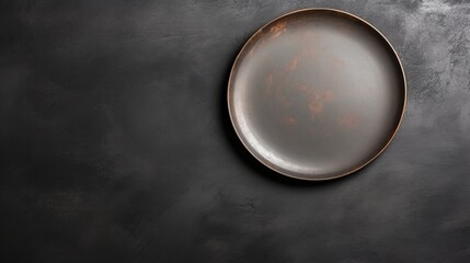An empty black plate with cutlery on a dark concrete background. Home dinner cooking on stone table