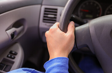 hands firmly grip a steering wheel, symbolizing control, safety, and the journey of life. It captures the essence of responsible travel and the importance of being in command