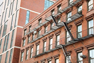 fire escape staircase zigzags outside a brick building, representing escape routes, emergency...