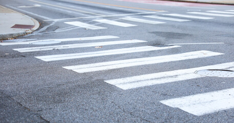crosswalk on urban street, painted white lines symbolize safety and community, pedestrians crossing, city life, traffic, pedestrian-friendly environment, road safety, walking, urban infrastructure
