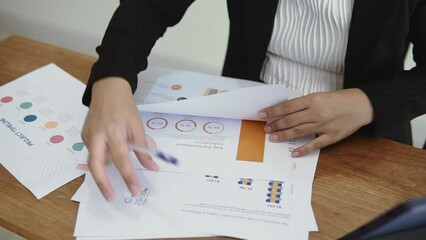 Asian woman working on financial planning on documents Successful professional woman working, close up shot.