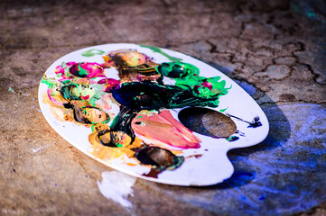 Obraz na płótnie Canvas colorful paints spread on a white palette on top of a wooden desk