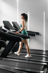 Fototapeta premium Asian woman is running on treadmill in gym.