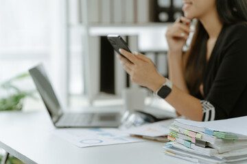 Asian woman sitting at a desk working in the office use a computer, laptop