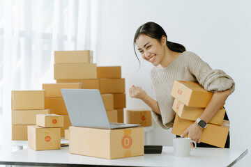 ortrait of a small business startup, SME owner, female entrepreneur, working, unboxing, checking orders online. To prepare to pack boxes for sale to SME customers online business ideas