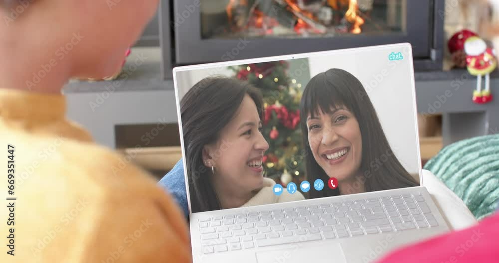 Sticker Diverse mother, daughter and male friends having christmas laptop video call, slow motion