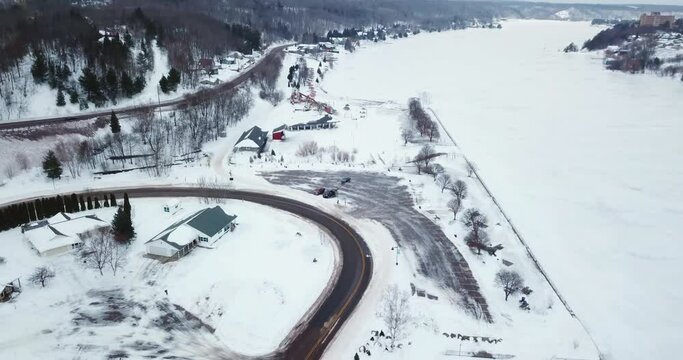 Aerial Shot Of Houses And Trees Near Frozen Portage Lake During Winter - Houghton, Michigan